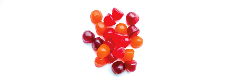  Group of red, orange and purple multivitamin gummies isolated on white background. Healthy lifestyle concept.